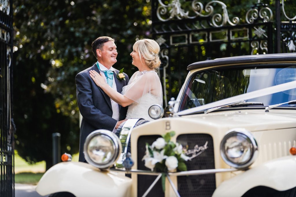 Luxury art deco hotel in Doncaster couple embrace by the wedding car
